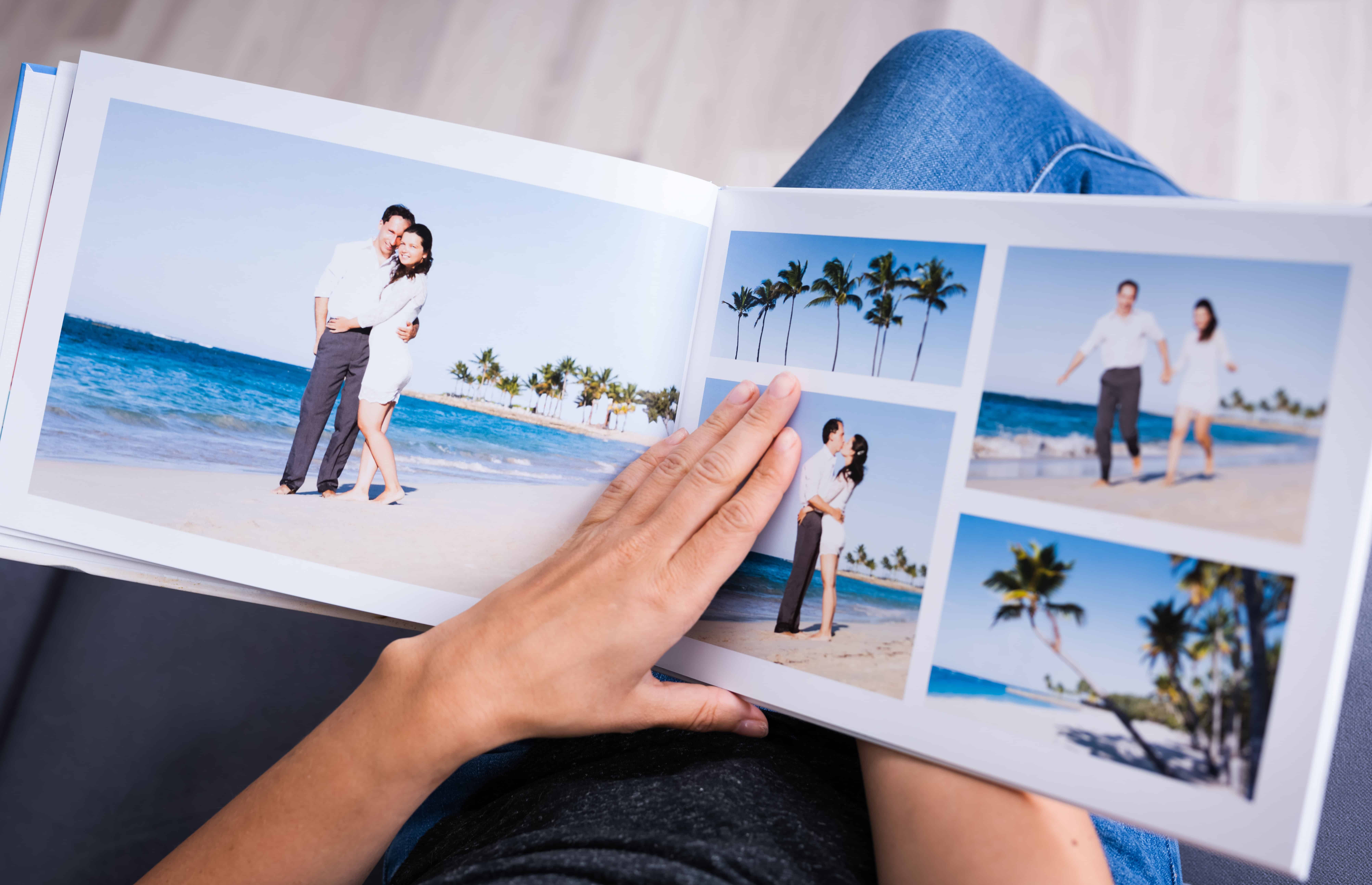 open photo book with pictures of couple on beach